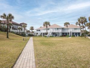 a large house with palm trees and a walkway at Sunrise Villa in Ponte Vedra