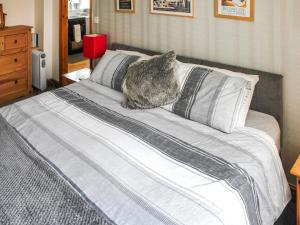 a bed with a cat sitting on top of it at Daisy Apartment in Stalham