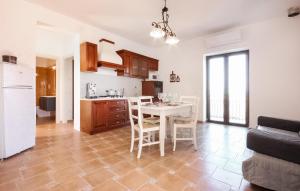 eine Küche und ein Esszimmer mit einem weißen Tisch und Stühlen in der Unterkunft Amazing Apartment In Perdifumo With Kitchen in Perdifumo