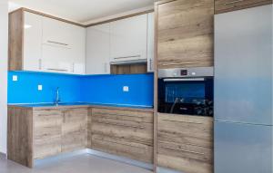 a kitchen with wooden cabinets and a refrigerator at Amazing Apartment In Pag With Wifi in Pag