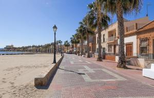 ulica z palmami i światłem ulicznym na plaży w obiekcie Nice Apartment In Los Alcazares w mieście Los Alcázares