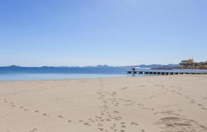 odciski stóp w piasku na plaży z molo w obiekcie Nice Apartment In Los Alcazares w mieście Los Alcázares