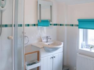 a white bathroom with a sink and a shower at Glanllyn Lodge in Llanuwchllyn