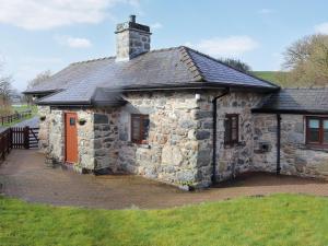 an old stone building with a chimney on top at Glanllyn Lodge in Llanuwchllyn