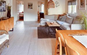 ein Wohnzimmer mit einem Sofa und einem Tisch in der Unterkunft Stunning Home In Hjlteby With Kitchen in Hjälteby