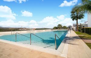 a swimming pool with blue water and palm trees at 3 Bedroom Amazing Apartment In Estepona in Estepona +10 photos