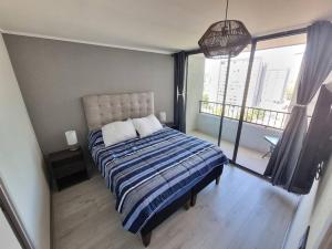 a bedroom with a bed and a large window at Hermoso y cómodo departamento in Santiago