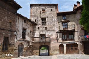 un antiguo edificio de piedra con puerta y balcones en Vista al Castillo de Mora de Rubielos VUTE-22-036, en Mora de Rubielos