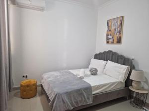 um quarto com uma cama grande e uma cabeceira cinzenta em Aliança Refúgio à Beira-Mar em Praia
