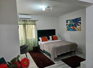 ein Schlafzimmer mit einem Bett und einem Gemälde an der Wand in der Unterkunft Apartman NENA 102 in Mostar