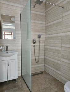 ein Badezimmer mit Dusche und Waschbecken in der Unterkunft Apartman NENA 102 in Mostar