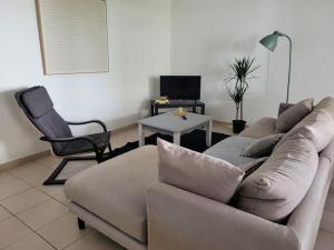 a living room with a couch and a chair at T3 proche bus et tram in Angers