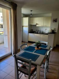 a kitchen with a table and chairs and a kitchen with a refrigerator at T3 proche bus et tram in Angers