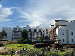 a row of apartment buildings on a hill at DANS LES BRAS DE NEPTUNE - Plage de TRESTRAOU - Piscine - 4 à 5 personnes in Perros-Guirec