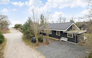 a small black house with a gravel driveway at Lovely Home In Hadsund With Kitchen in Hadsund +7 photos