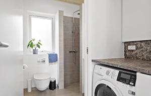 uma casa de banho com uma máquina de lavar roupa e um chuveiro em Lovely Home In Hadsund With Kitchen em Hadsund