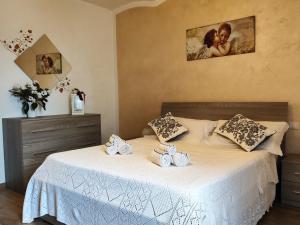 a bedroom with two beds with white linens and a picture at La Piccola Loggia in Torrita di Siena