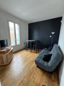 uma sala de estar com um sofá e uma mesa em Grand Paris cocooning à 5 minutes de la gare em Pavillons-sous-Bois