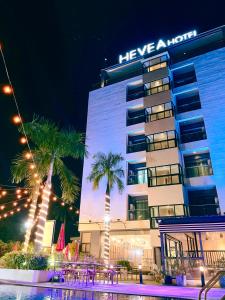 a hotel with palm trees in front of a building at Hevea Hotel & Resort in Angeles