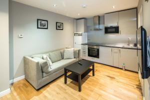 ein Wohnzimmer mit einem Sofa und einem Tisch in der Unterkunft Cosy 2-Beds, Shepherd Bush in London