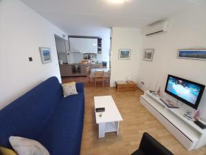 a living room with a blue couch and a tv at Apartment Mystic in Split