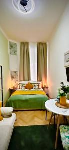 ein Schlafzimmer mit einem grünen Bett und einem Tisch in der Unterkunft ST Apartment in Wien