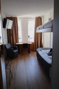 - une chambre avec des lits superposés, un bureau et une chaise dans l'établissement Hesehotelli Turku Linja-autoasema, à Turku