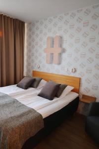 a bedroom with two beds and a cross on the wall at Hesehotelli Turku Linja-autoasema in Turku