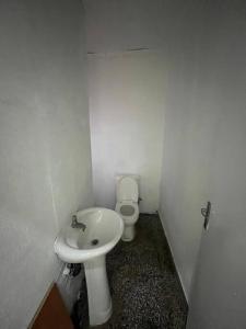 La petite salle de bains est pourvue de toilettes et d'un lavabo. dans l'établissement Lx Apart in Sommerschield 2, à Maputo