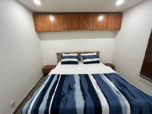 a bedroom with a bed with blue and white stripes at Lx Apart in Sommerschield 2 in Maputo