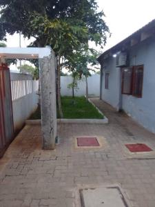 a brick courtyard with a building and a tree at Lx Apart in Sommerschield 2 in Maputo