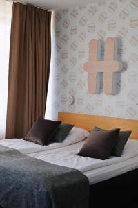a bedroom with two beds with a cross on the wall at Hesehotelli Turku Linja-autoasema in Turku