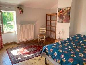 1 dormitorio con 1 cama, 1 silla y 1 ventana en Gite des Noisettes à la porte de Saintes, en Chermignac