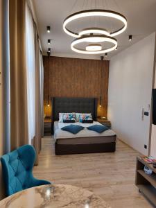 a bedroom with a bed and a chandelier at Silver Dawn Apartments in Szeged