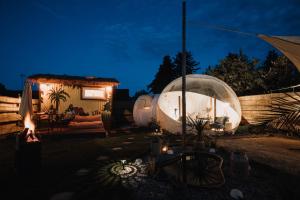 un patio trasero con un iglú y una casa por la noche en Alpacosi Oase - Schlafen unter den Sternen, en Zehdenick