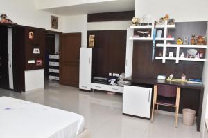 a bedroom with white cabinets and a bed and a table at MAHAMAYA HOME STAY in Mysore