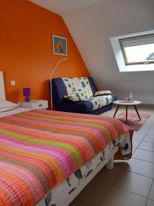 ein Schlafzimmer mit einem Bett und einem Stuhl in der Unterkunft Auprès de mon arbre in Saint-Gildas-de-Rhuys