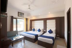 a hotel room with two beds and a table at Hotel Katra Residency in Katra