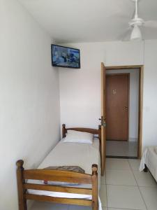 um quarto com uma cama e uma fotografia na parede em Pousada Peruíbe Frente ao Mar - Suítes Gourmet em Peruíbe