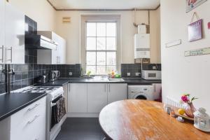 a kitchen with white appliances and a wooden table at Keysan House 5 in London
