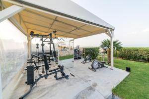 een fitnessruimte met een paviljoen met fietsen en gewichten bij Villa Constandinos - Private Pool - Sleeps 8 in Chersonissos