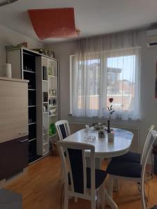 a dining room with a white table and chairs at Greatly located/parking/balcony/2 bathrooms in Zagreb