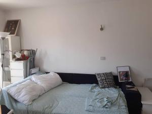 a bedroom with a bed and a white wall at Greatly located/parking/balcony/2 bathrooms in Zagreb