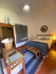 a small bedroom with a bed and a table at Pouso da Ermelinda in Tiradentes