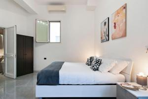 Un dormitorio blanco con una cama y un baño. en Obelisk Studio - Lecce Selection, en Lecce