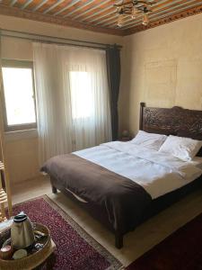 Un dormitorio con una cama grande y una ventana en Cappadocia Cave Sinasos Villa, en Mustafapaşa