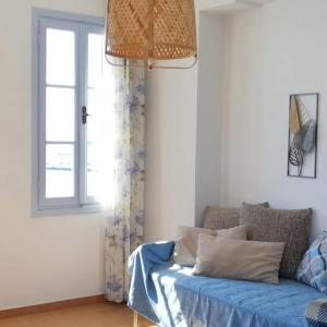a living room with a blue couch and a window at Aegina Port Apt 2-Διαμέρισμα στο λιμάνι της Αίγινας 2 in Egina