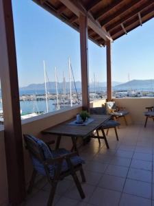 um alpendre com uma mesa e cadeiras e vista para um porto em Aegina Port Apt 2-Διαμέρισμα στο λιμάνι της Αίγινας 2 em Egina