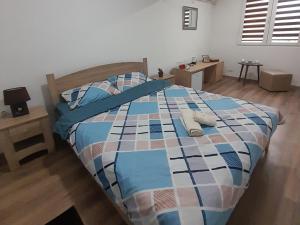 Schlafzimmer mit einem Bett mit einer blauen und weißen Bettdecke in der Unterkunft Dany Apartments in Gevgelija