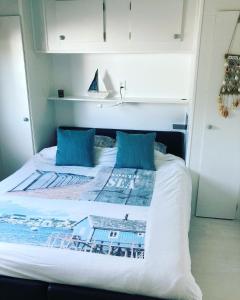 een bed met twee blauwe kussens erop bij Zeebries in Makkum